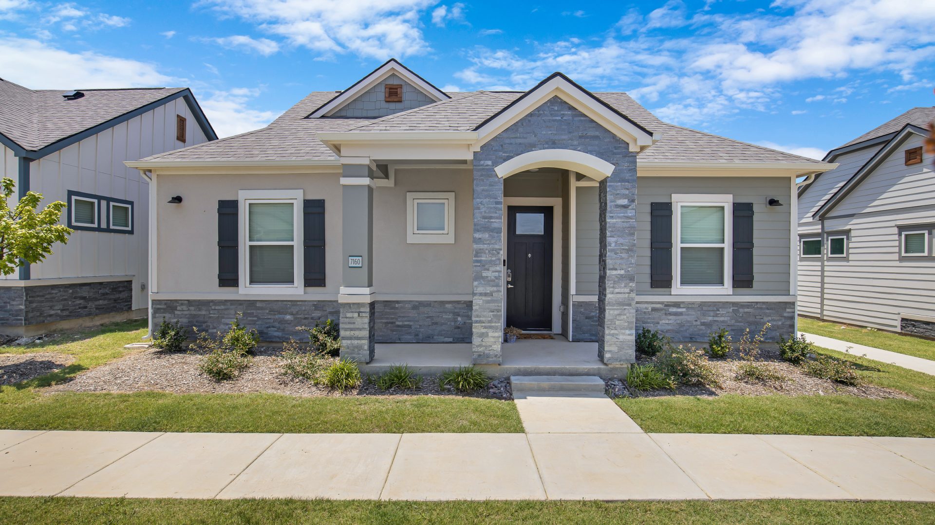 a home with a front yard and a driveway at The VLux Trails